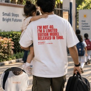 Father wearing Blessico oversized white T-shirt while carrying his daughter near a school